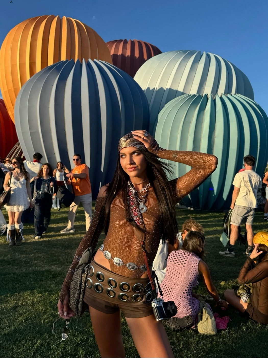 a baddie in the balloon field at a festival, the crowd and the balloons behind her