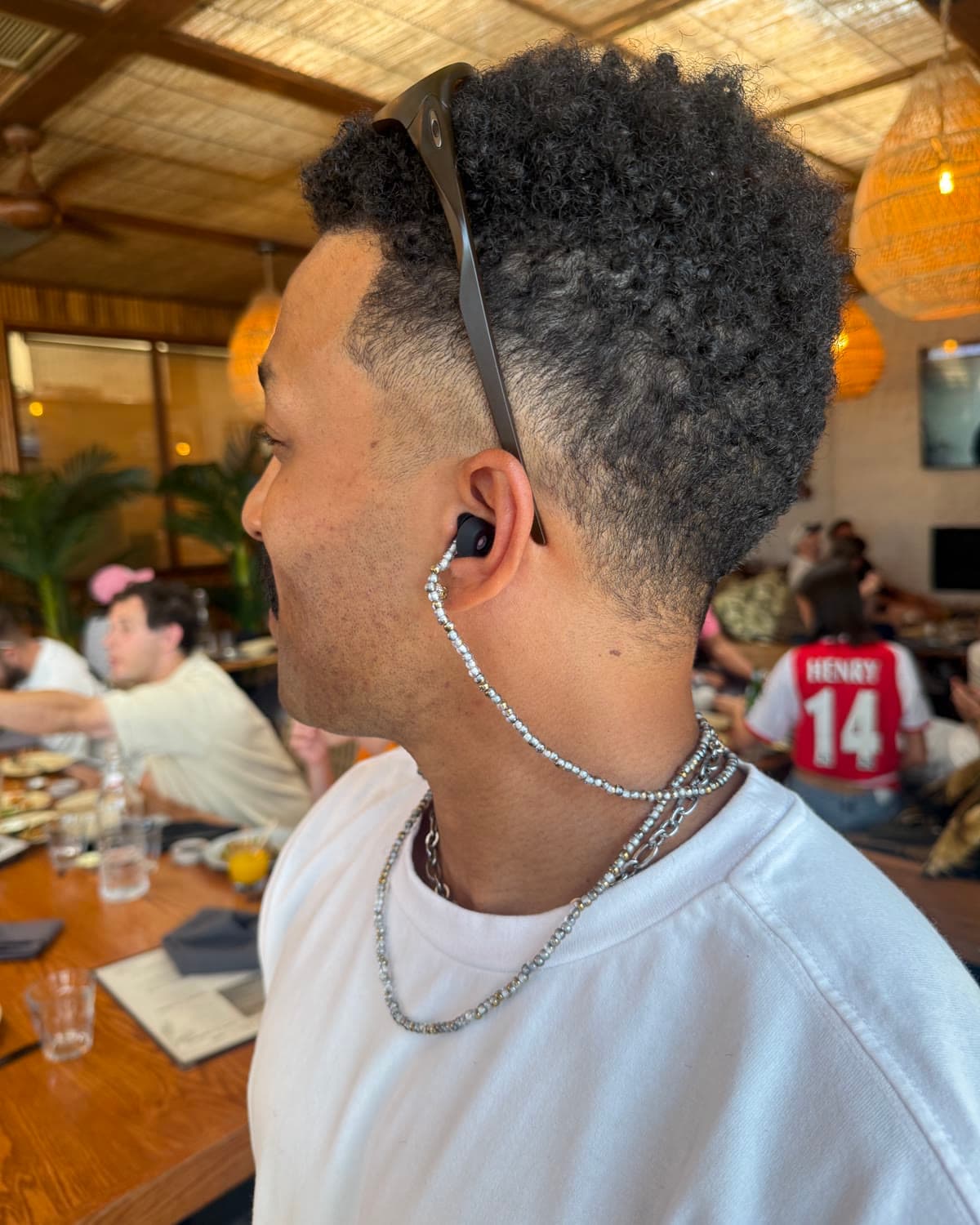 the same silver chain from behind, doubled around his neck
