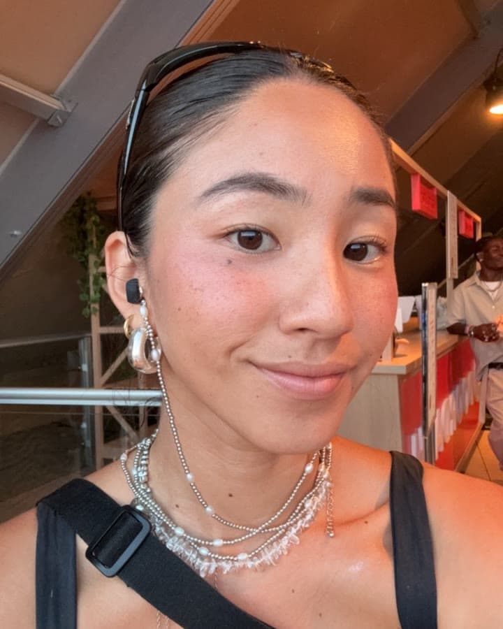 a silver chain hanging from the earplug in her ear and looped around her neck